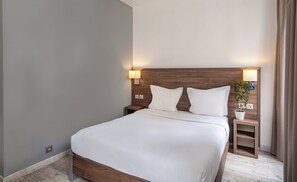 A neatly made bed with white linens in a modern hotel room. - Hotel La Perle Montparnasse (Paris)