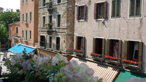 A row of buildings with balconies, some with flower boxes. - Casa delle Ortensie (Venice)