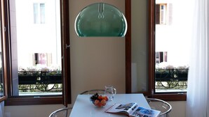 A dining area with a table, a bowl of fruit, a glass pitcher, and a magazine. - Casa delle Ortensie (Venice)