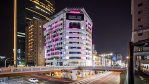 Un hotel de varios pisos con un diseño moderno, que cuenta con balcones y una entrada destacada.