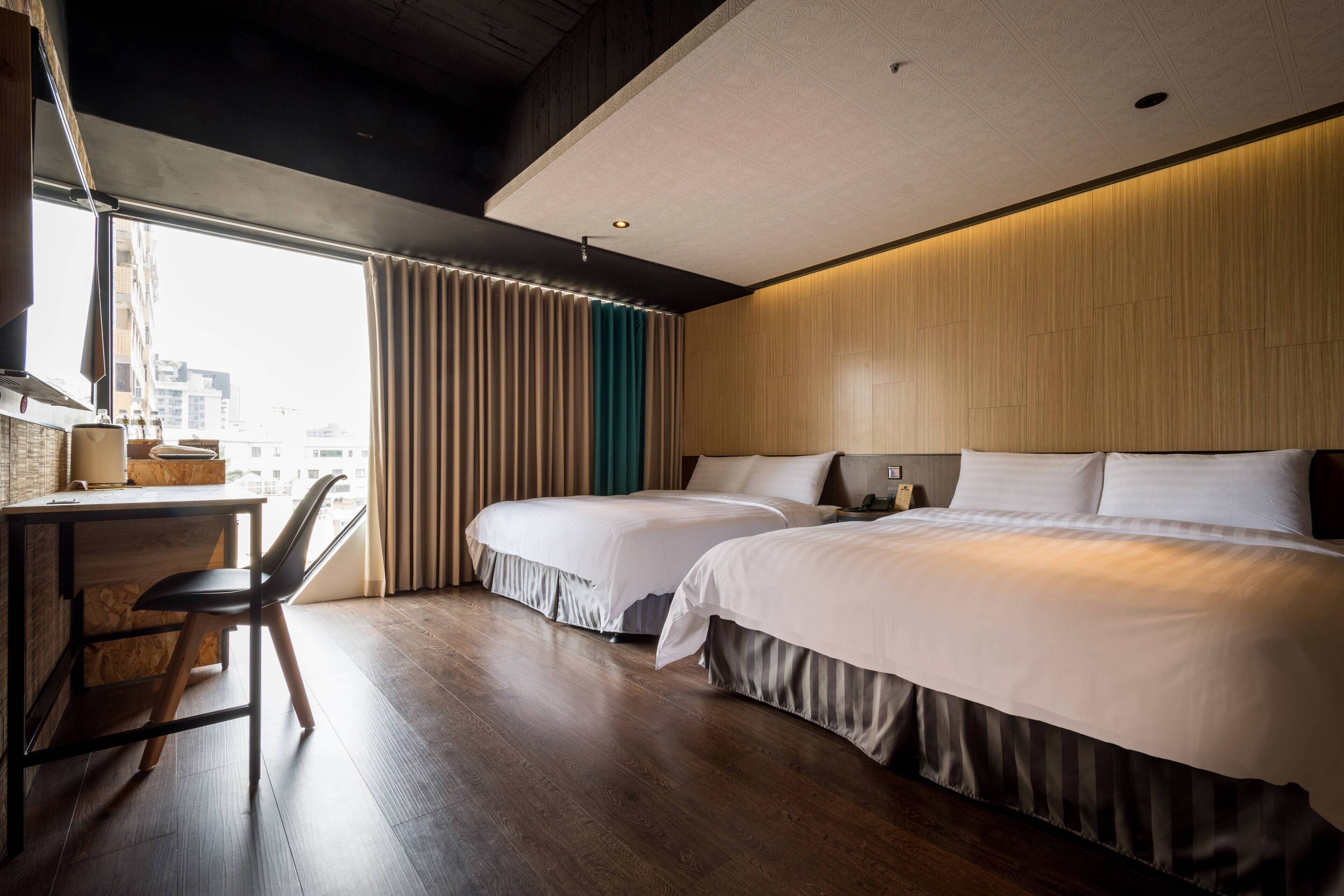 Una habitación de hotel con dos camas, un escritorio y una silla.