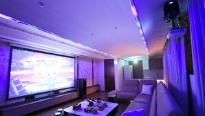 Una sala de estar moderna con un televisor de pantalla plana grande, un sofá y una mesa de centro.