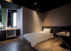 A modern bedroom with a bed, a desk with a mirror, and a window. - Calligraphy Greenway Hotel (Taichung)