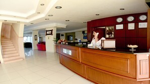 A reception area with a wooden counter, a staircase, and a tiled floor. - Eylul Hotel (Erdemli)