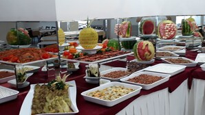 A buffet with various food items and decorative fruit sculptures. - Eylul Hotel (Erdemli)