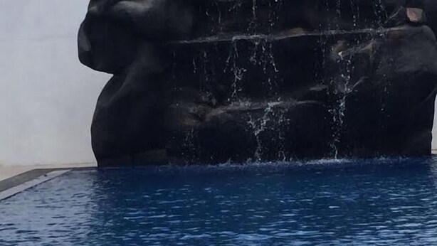 A pool with a water feature in the center.