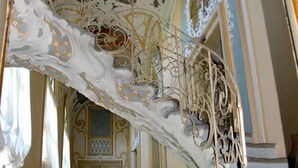 Un pasillo ornamentado con elaborados diseños en el techo y un suelo con motivos.