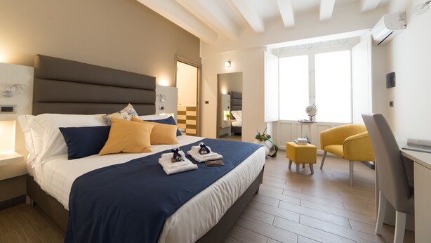 Una habitación de hotel moderna con una cama grande, un escritorio y una silla.