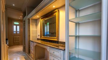 A spacious walk-in closet with built-in shelving and a large mirror.