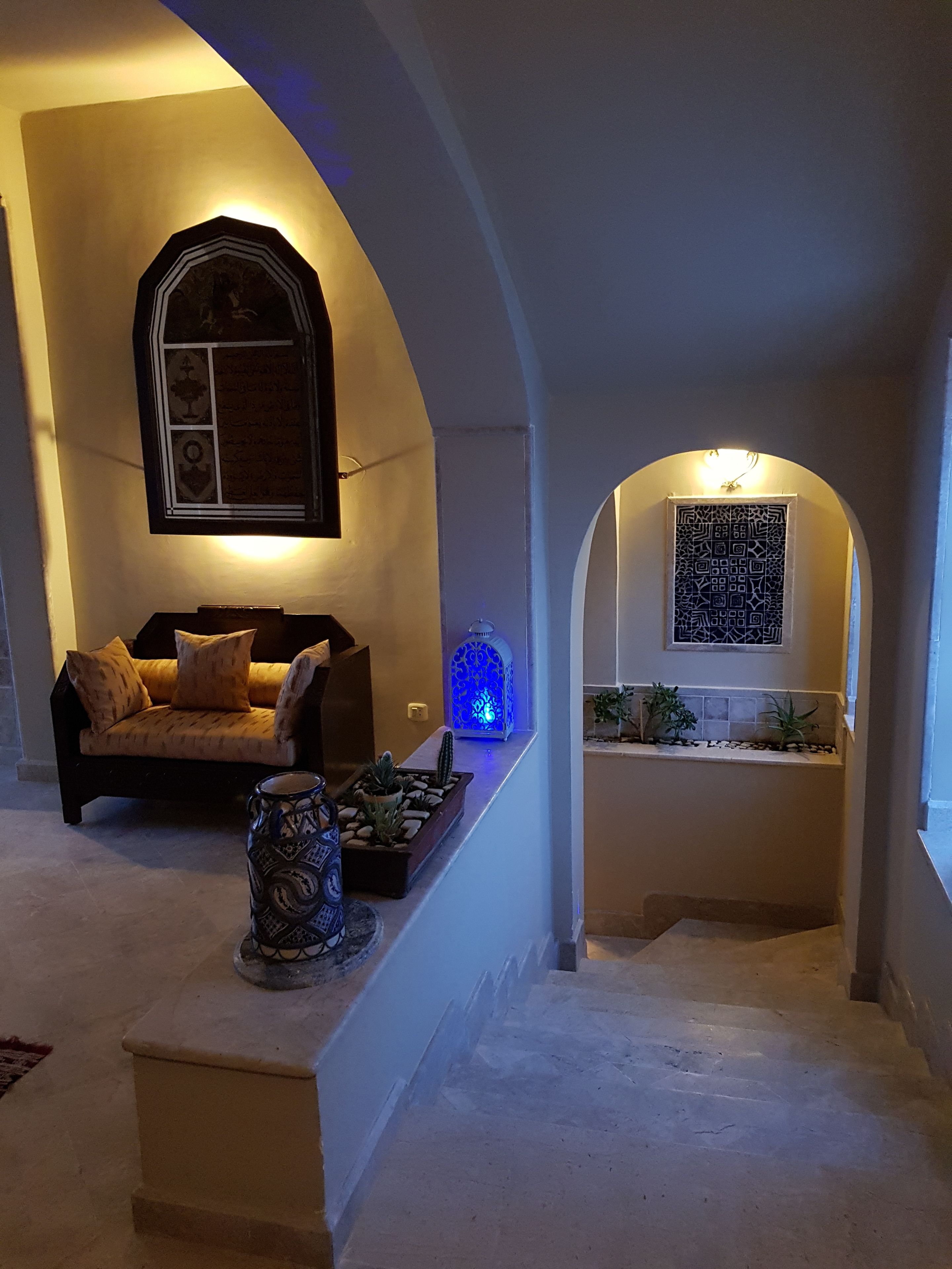 A cozy living area with a sofa, decorative vases, and a small plant arrangement.