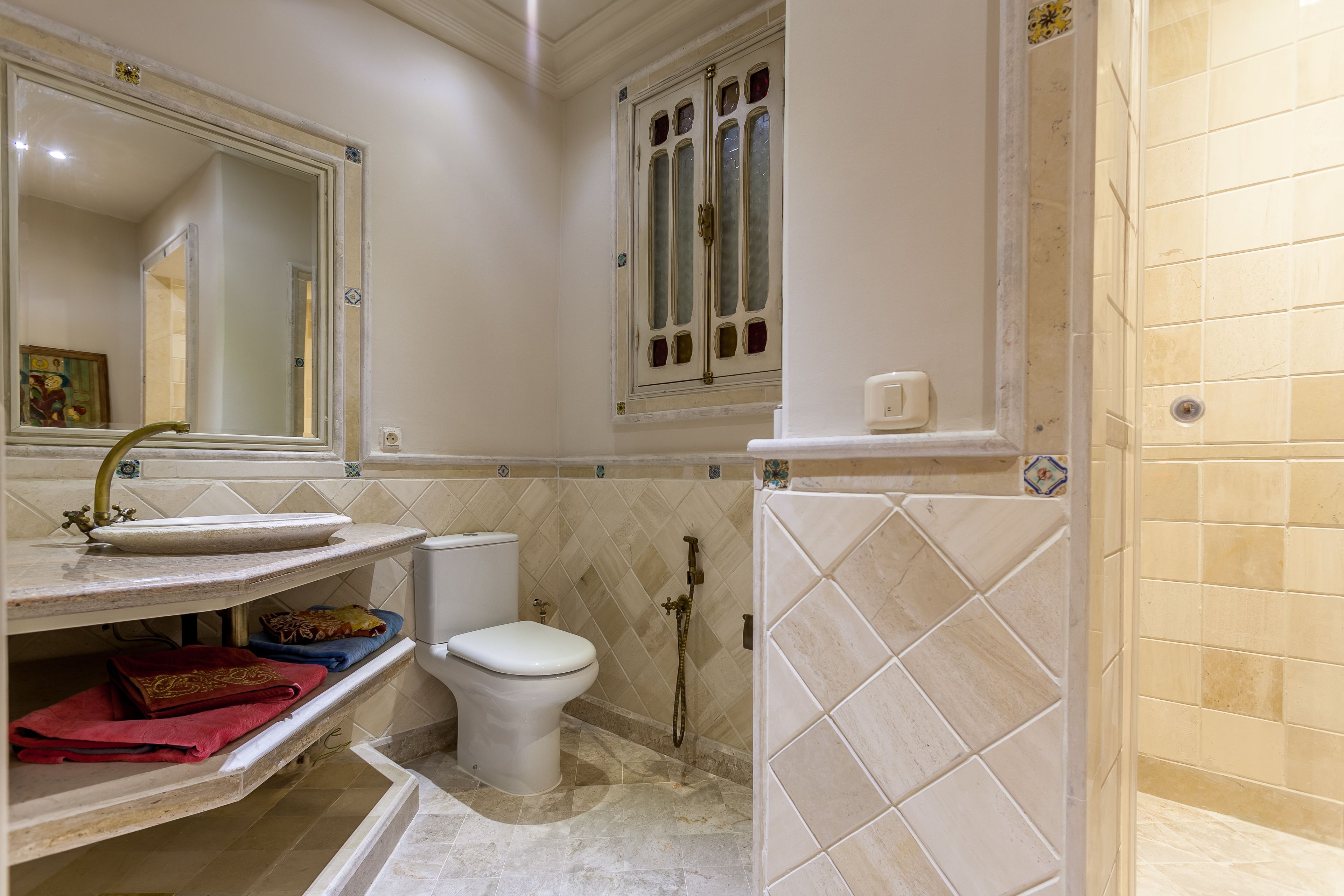 A bathroom with a sink, toilet, and shower area.