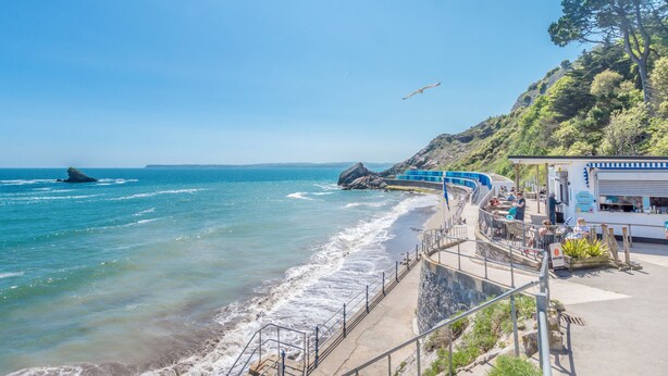 A coastal view with a pier, a restaurant, and a rocky shoreline. - The Hotel Balmoral - Adults Only (Torquay)