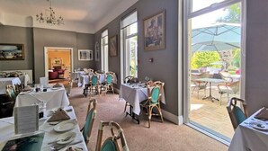 A dining area with tables set for service, large windows, and a view of the outdoors. - The Hotel Balmoral - Adults Only (Torquay)