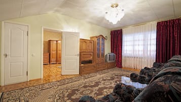 Habitación triple de lujo, terraza | Zona de estar | Una televisión