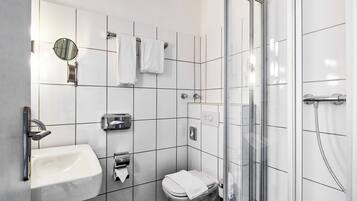 Uma casa de banho moderna com lavatório, sanita e cabine de duche em vidro.