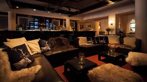 A modern lounge area with leather sofas, a bar, and ambient lighting. - Hotel Gersfelder Hof (Gersfeld)