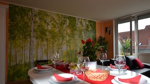 A dining table set with plates, glasses, and a basket of bread. - pur NATUR & berlin ALEX 40min. (Steinhoefel)