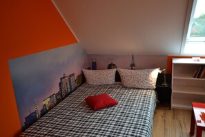 A bedroom with a checkered bedspread, a red pillow, and a cityscape mural on the wall. - pur NATUR & berlin ALEX 40min. (Steinhoefel)