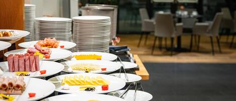 A buffet setup with various food items and stacked plates.