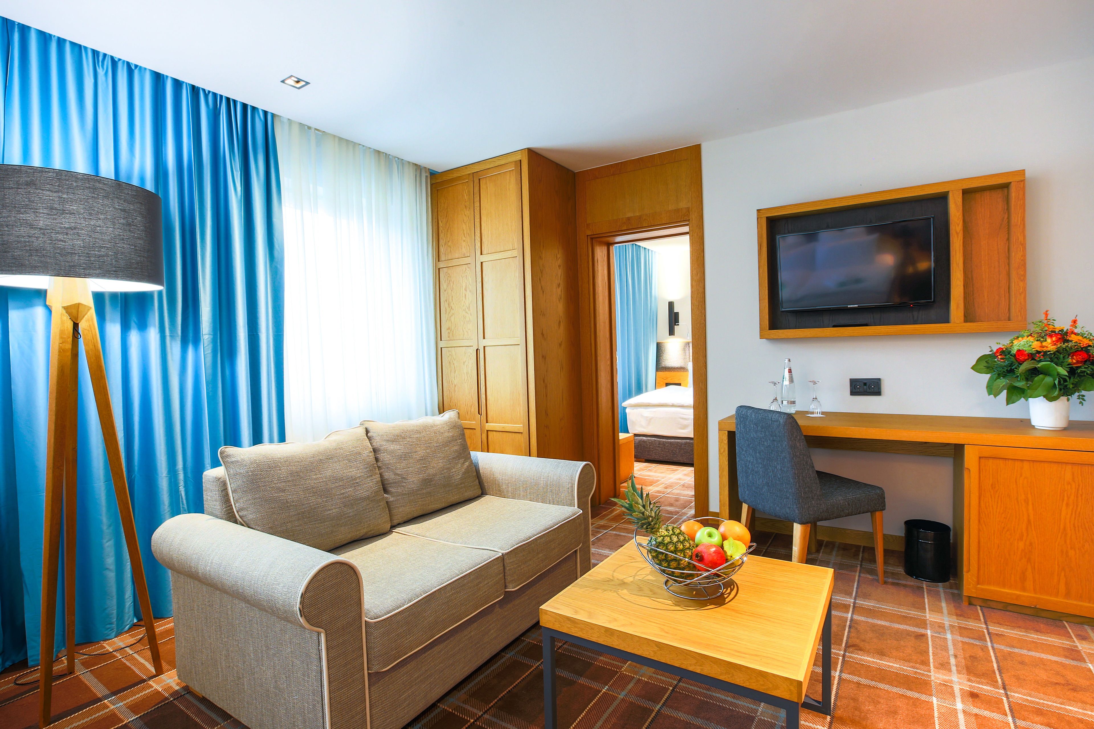 Una habitación moderna con sofá, una mesa de comedor con fruta, televisión y escritorio.