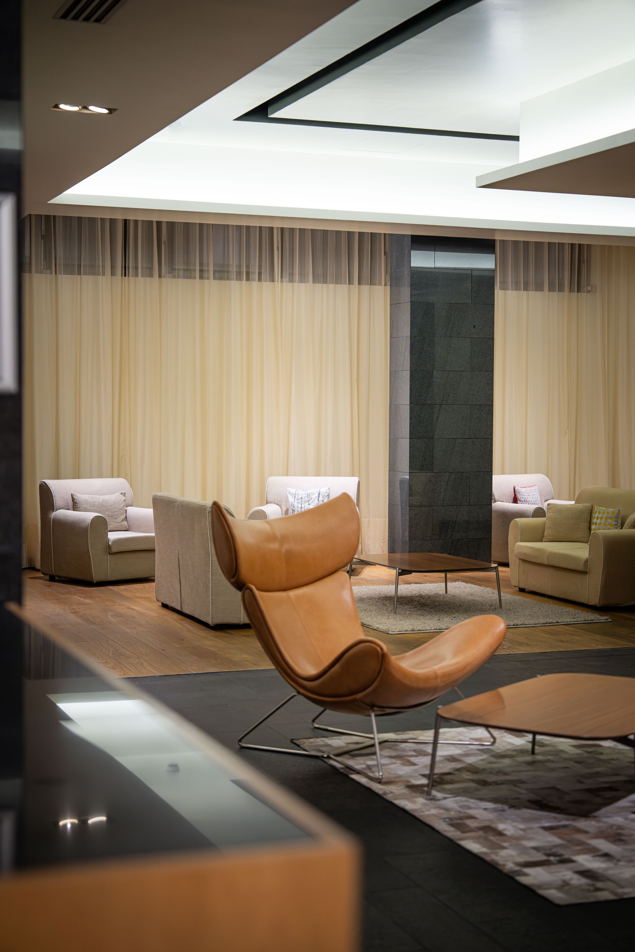 A modern living room with a sofa, armchairs, and a coffee table.