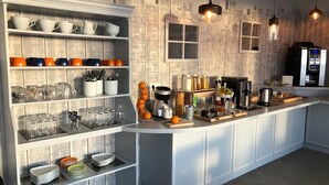 A modern kitchen with white cabinetry, a breakfast bar, and various kitchen appliances. - Les' Loges du Ried (Marckolsheim)