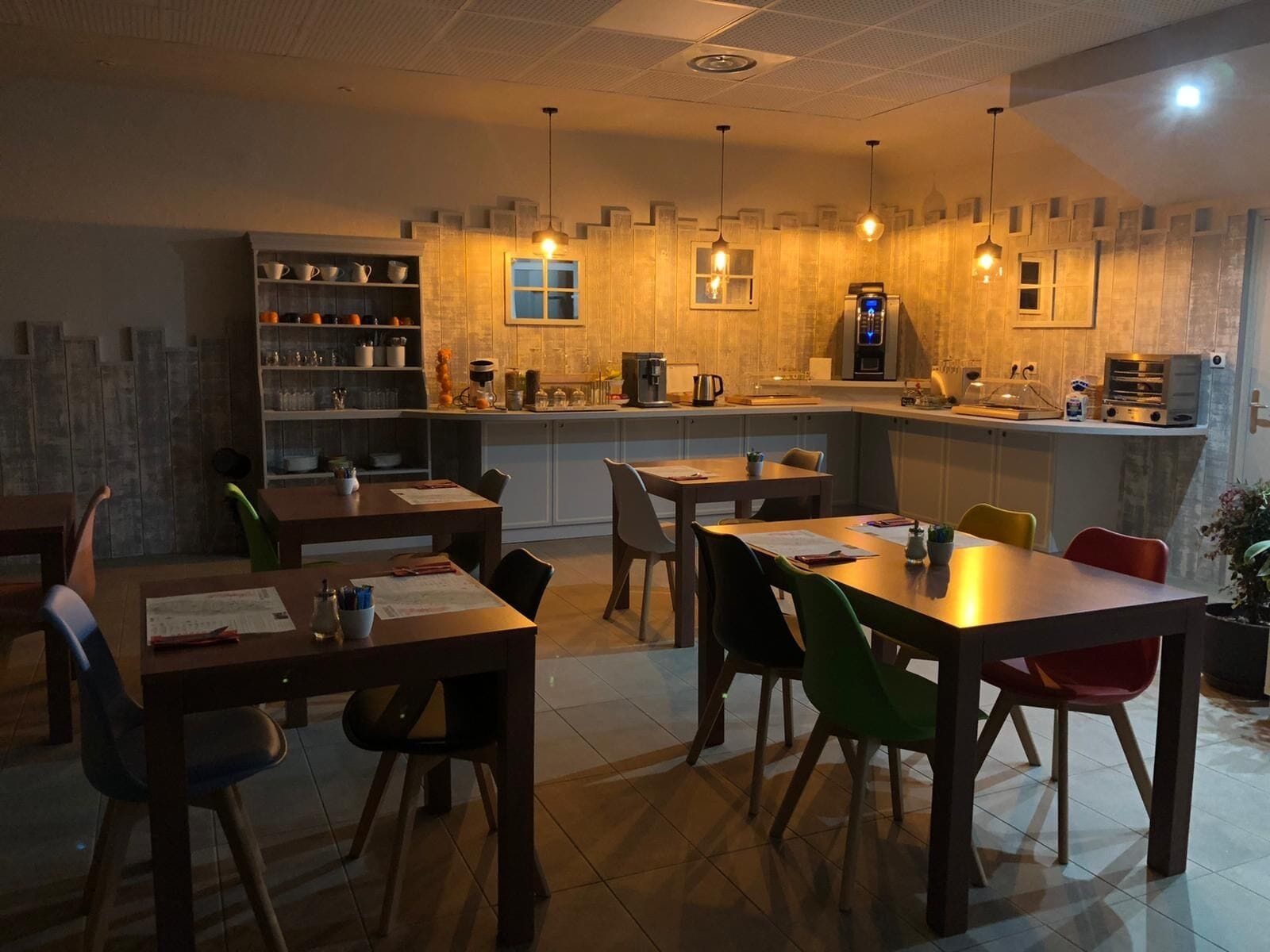 Una cocina moderna con una isla central, estanterías integradas y un comedor con múltiples sillas.