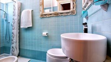 Une salle de bain avec des toilettes, un lavabo et une douche.