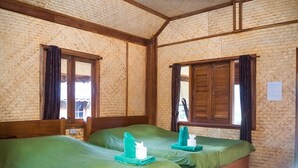 Una stanza con due letti di legno, biancheria verde e un soffitto intrecciato.