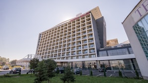 Un hotel de varios pisos con un diseño moderno, que destaca un letrero grande en la parte superior.