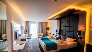 Una habitación de hotel con una cama grande, un escritorio, una silla y un televisor.