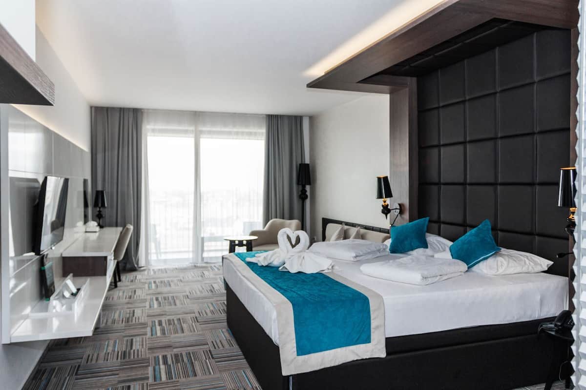 Ein modernes Hotelzimmer mit einem großen Bett, einem Schreibtisch und einer Sitzecke.