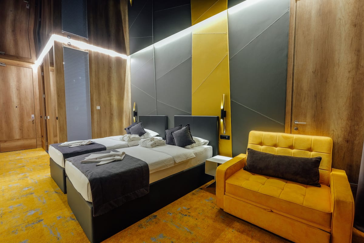 Ein modernes Hotelzimmer mit einem großen Bett, einer Couch und einem Nachttisch.