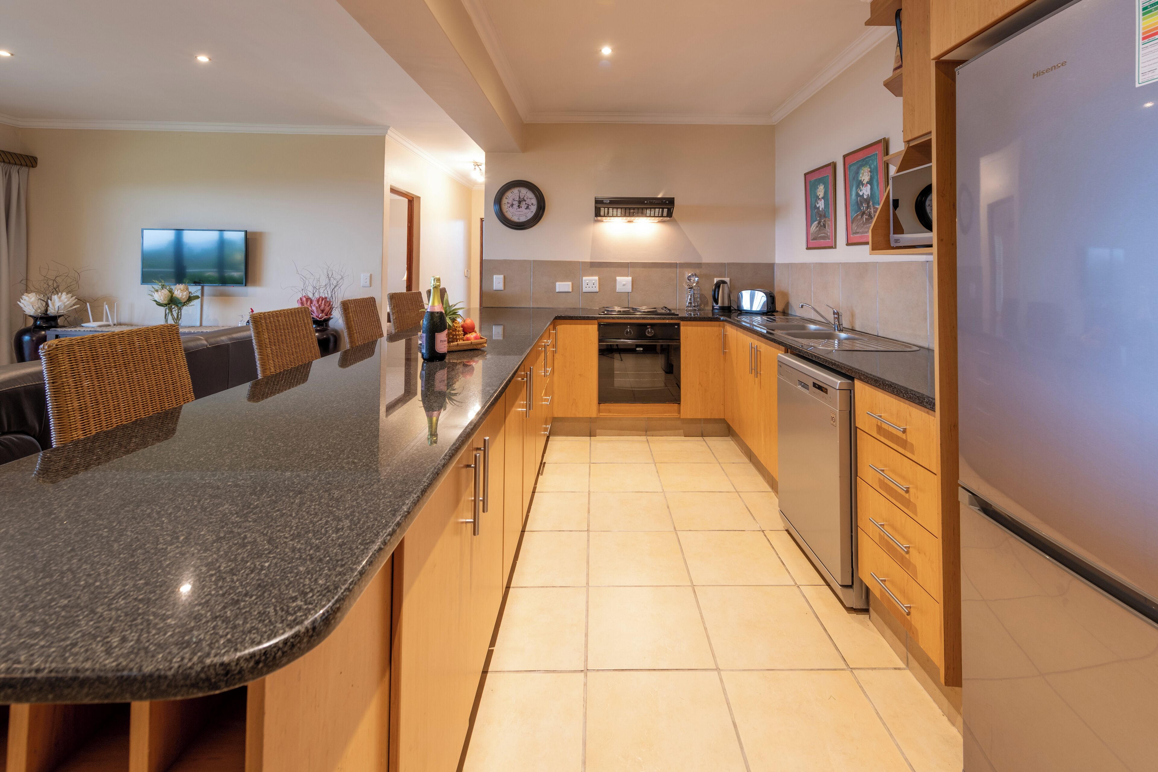Una cocina moderna con una isla central, armarios de madera y electrodomésticos de acero inoxidable.