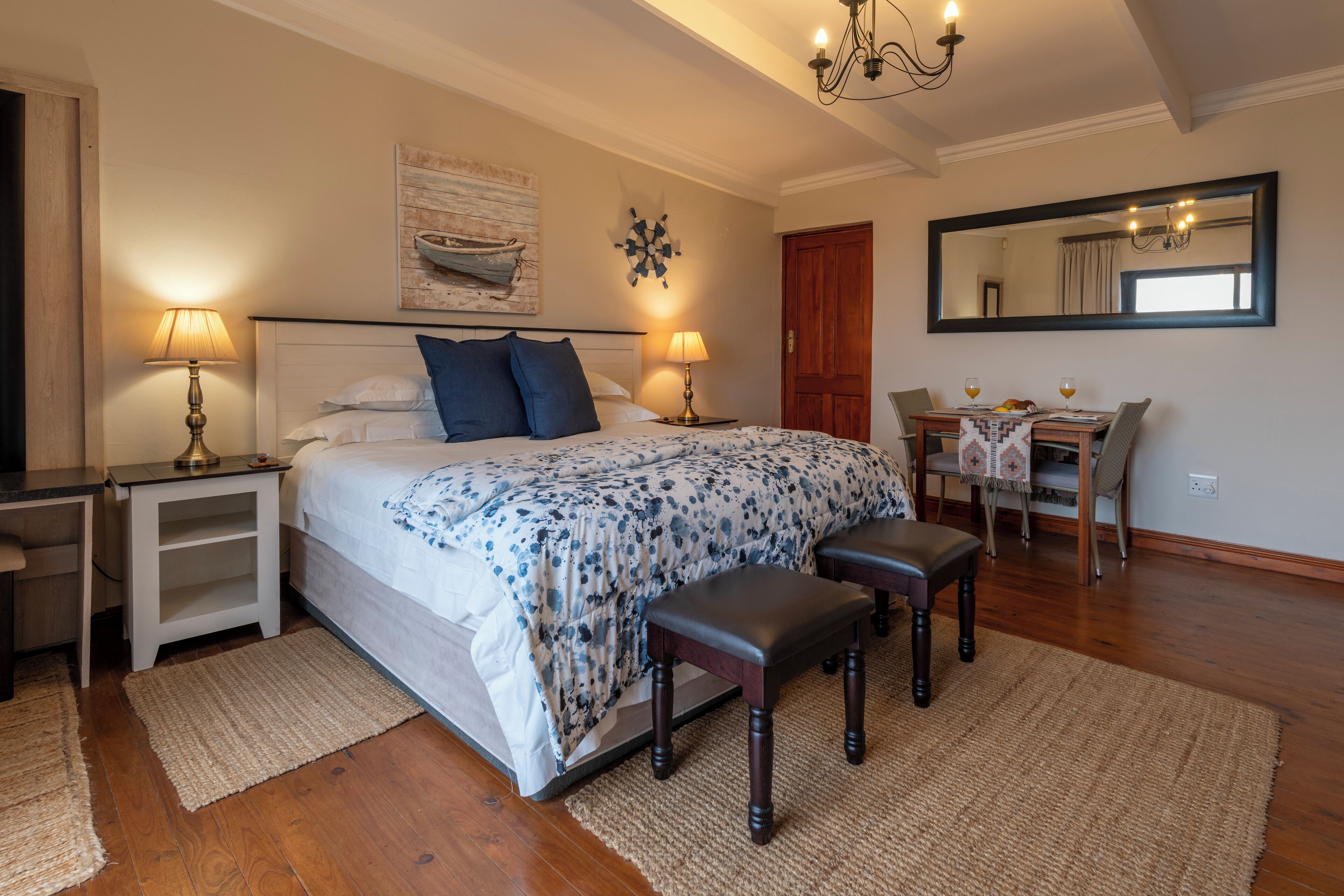 A bedroom with a bed, bedside tables, a desk, and a chair.