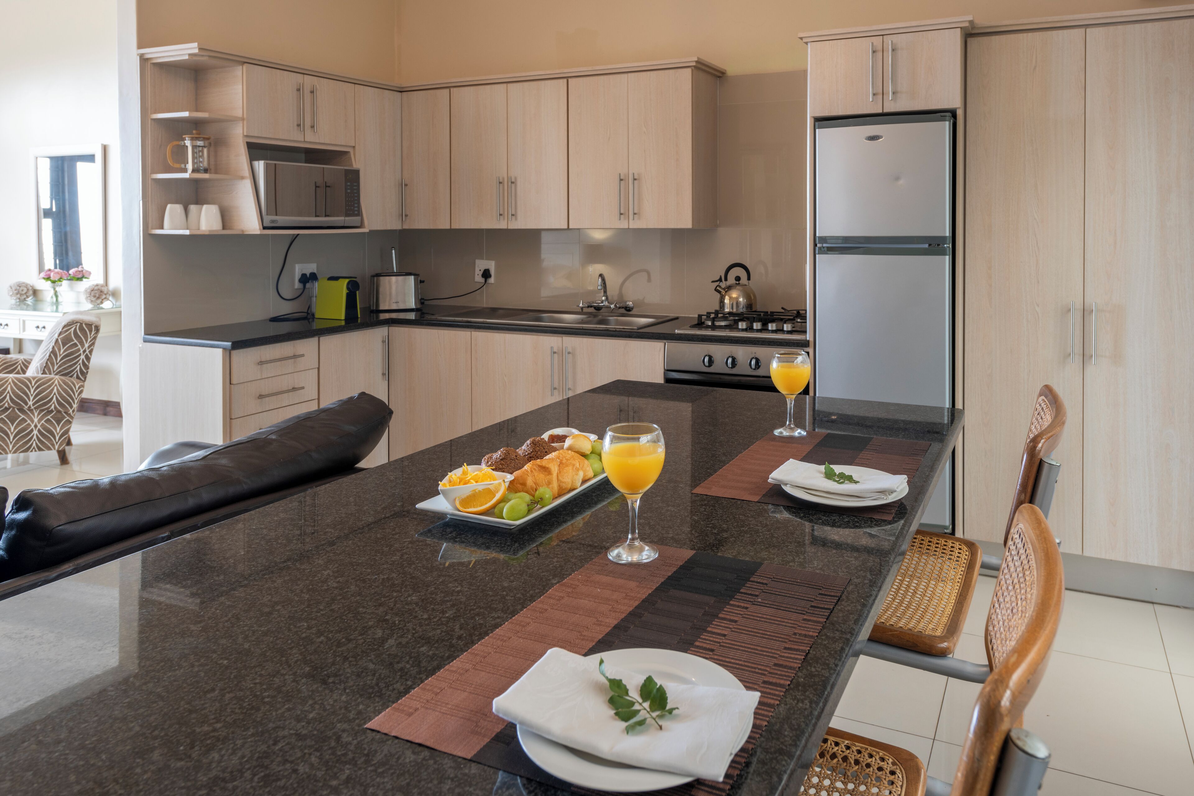 A modern kitchen with a central island, equipped with a microwave, stove, and refrigerator.