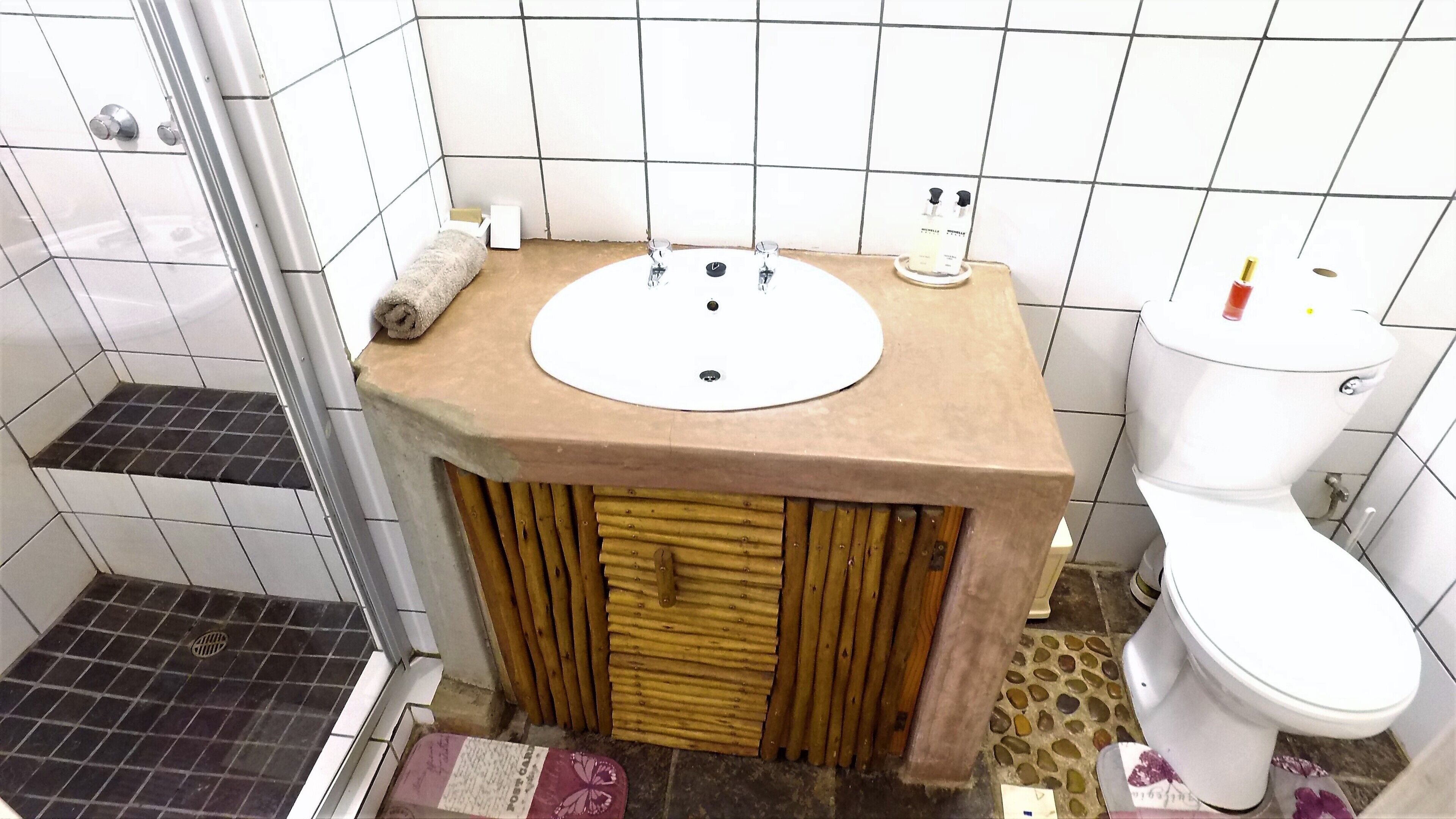 A bathroom with a white sink, toilet, and shower.