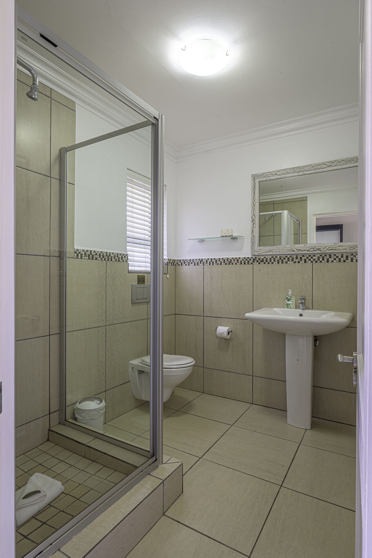 A bathroom with a shower, toilet, and sink.
