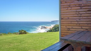 A wooden deck with a view of the ocean and a grassy area. - Fynbos Golf & Country Estate (Eersterivierstrand)