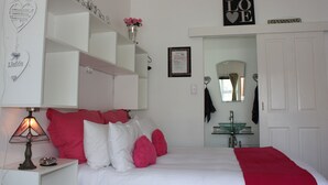 A bedroom with a bed, bedside table, lamp, and a wall with a 'LOVE' sign and a 'NO SMOKING' sign. - Knock Out View Clarens (Clarens)