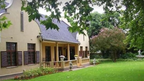 Un bâtiment doté d’un porche abrité, d’un jardin et d’une fontaine.