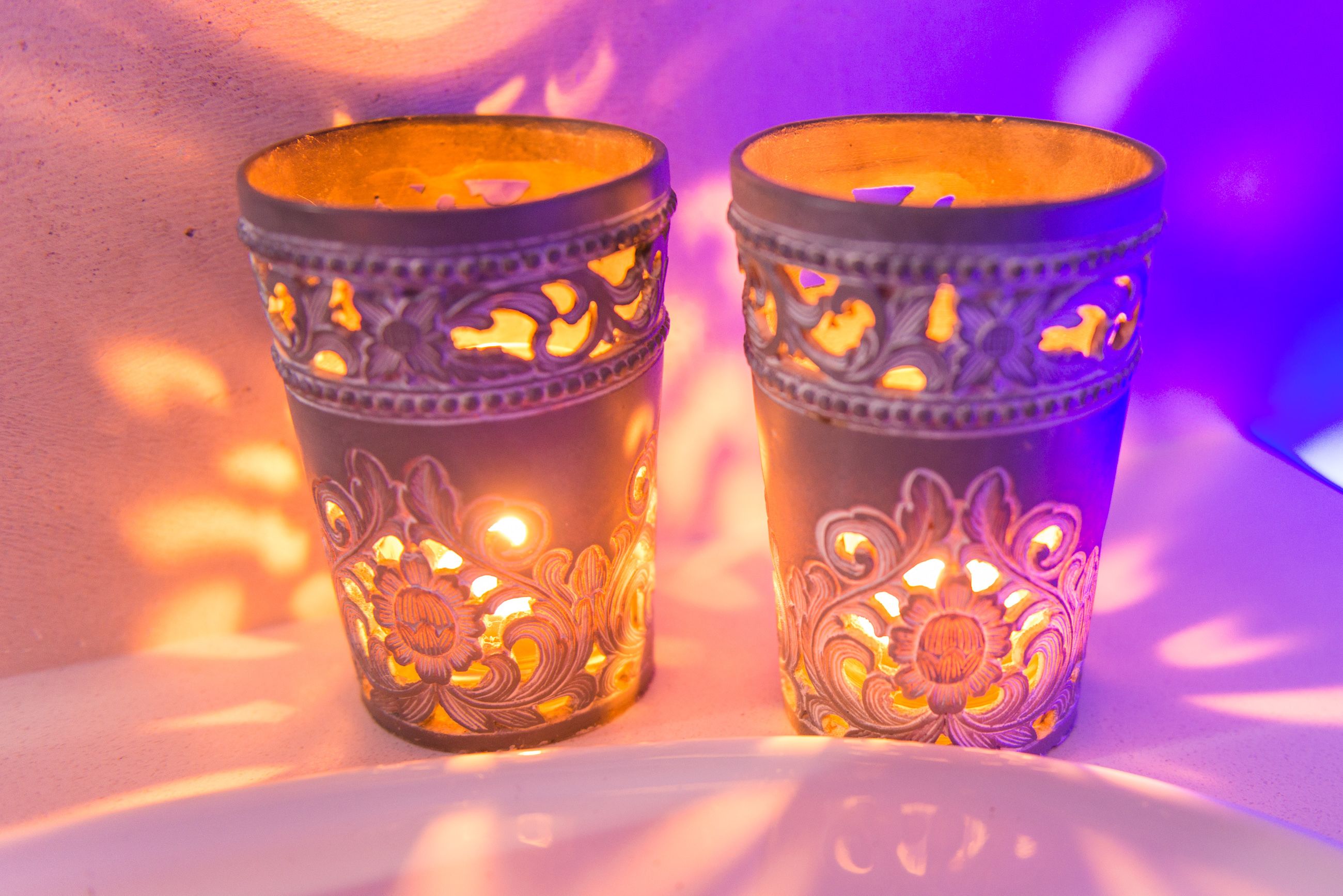 Two candle holders with intricate designs.