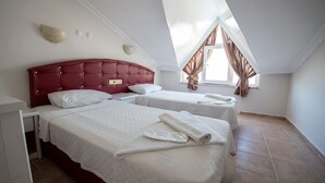 A bedroom with a red headboard, two beds, a window with curtains, and a skylight. - Basil's Apart Hotel (Marmaris)