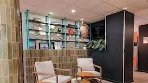A modern interior with two chairs, a small table, and shelves with various items.