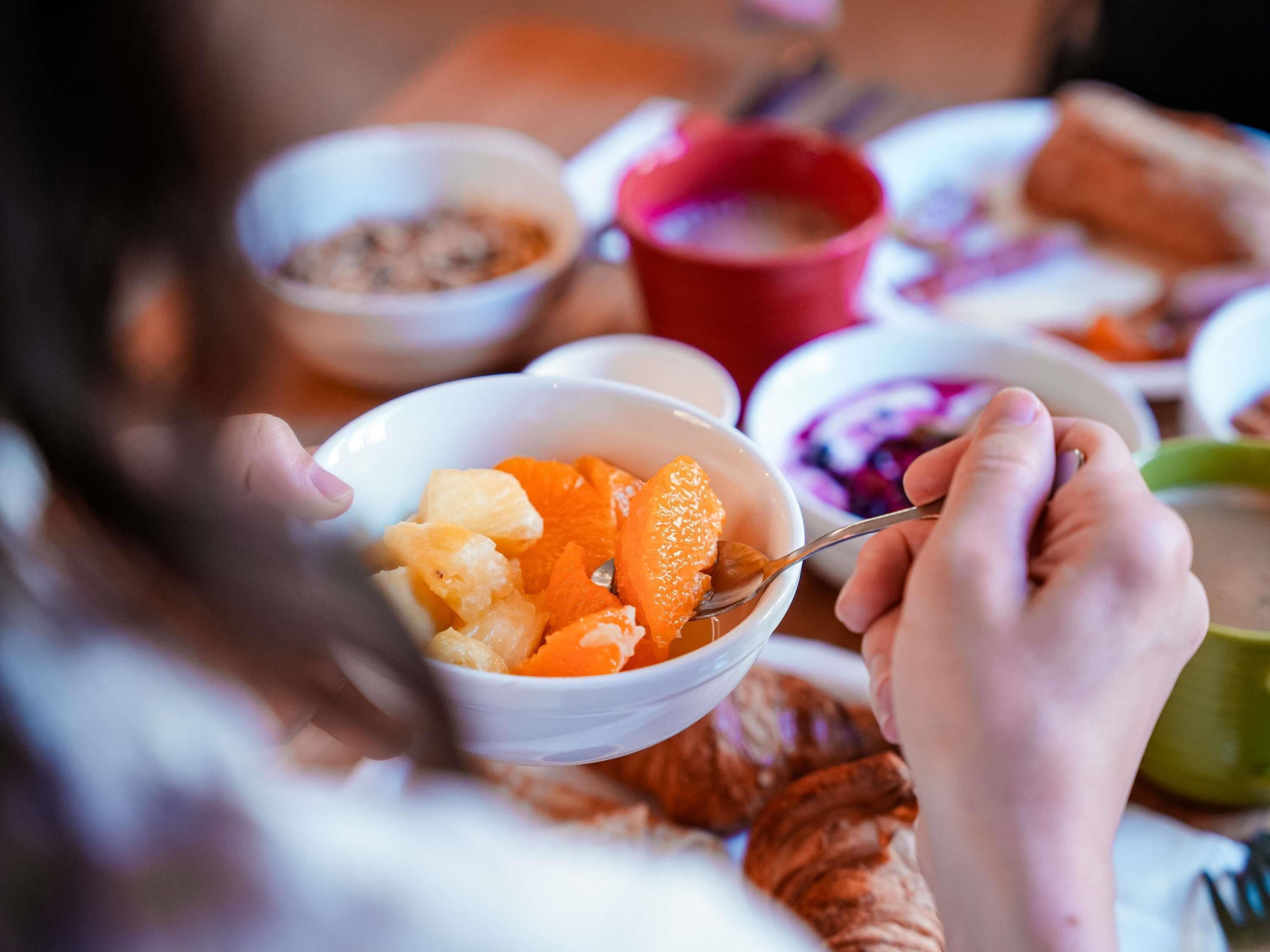 A person eating fruit from a bowl.