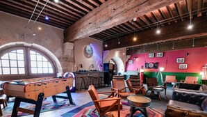 A cozy indoor space with a foosball table, comfortable seating, and a dartboard.