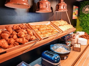 A breakfast buffet with croissants, bread, and a toaster. - Ibis Budget Marseille Vieux Port (Marseille)