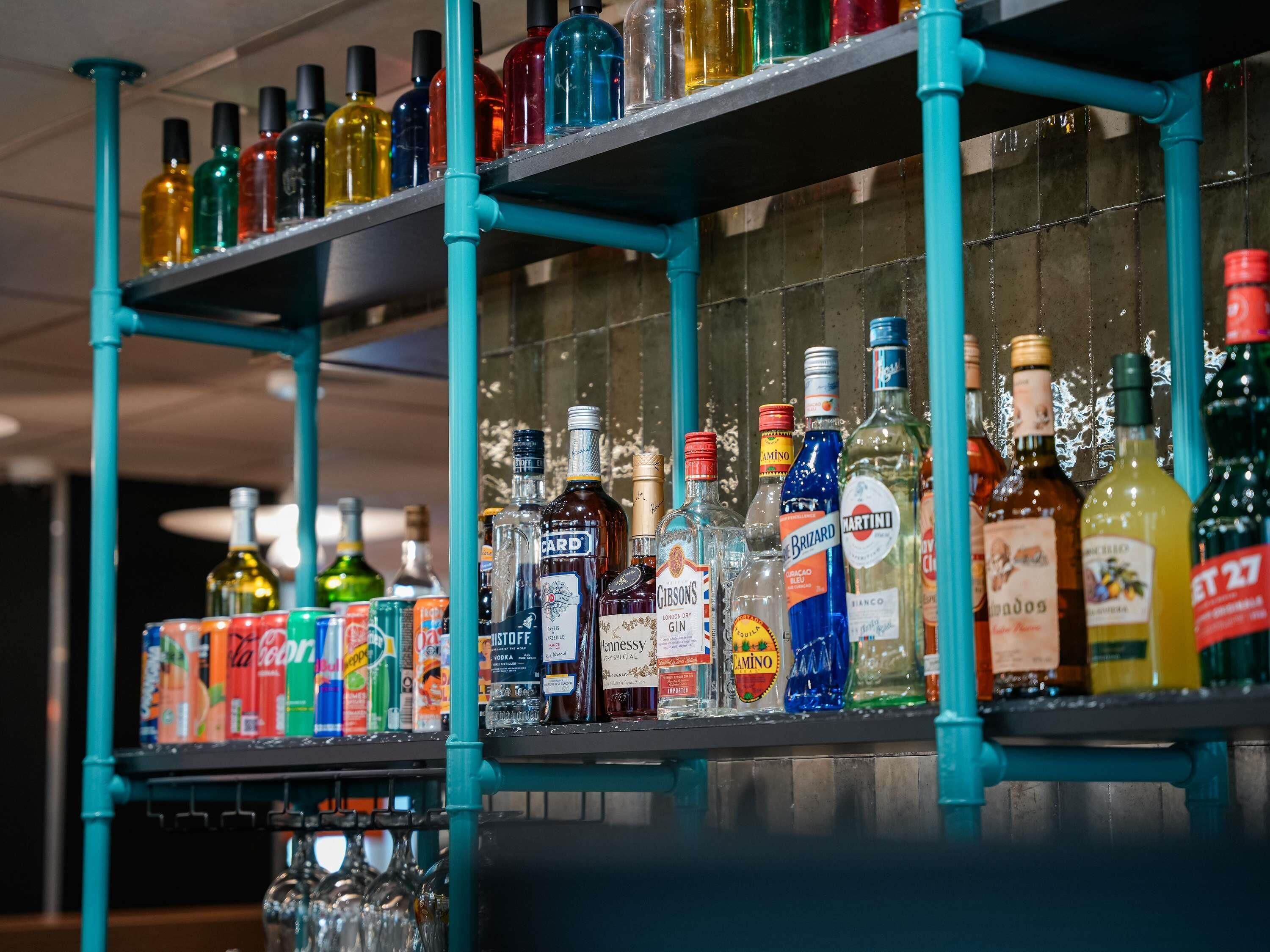 A bar area with shelves stocked with various liquor bottles and glasses.