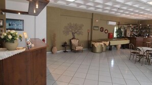 Un vestíbulo amplio con mostrador de recepción, zona de comedor y bar.