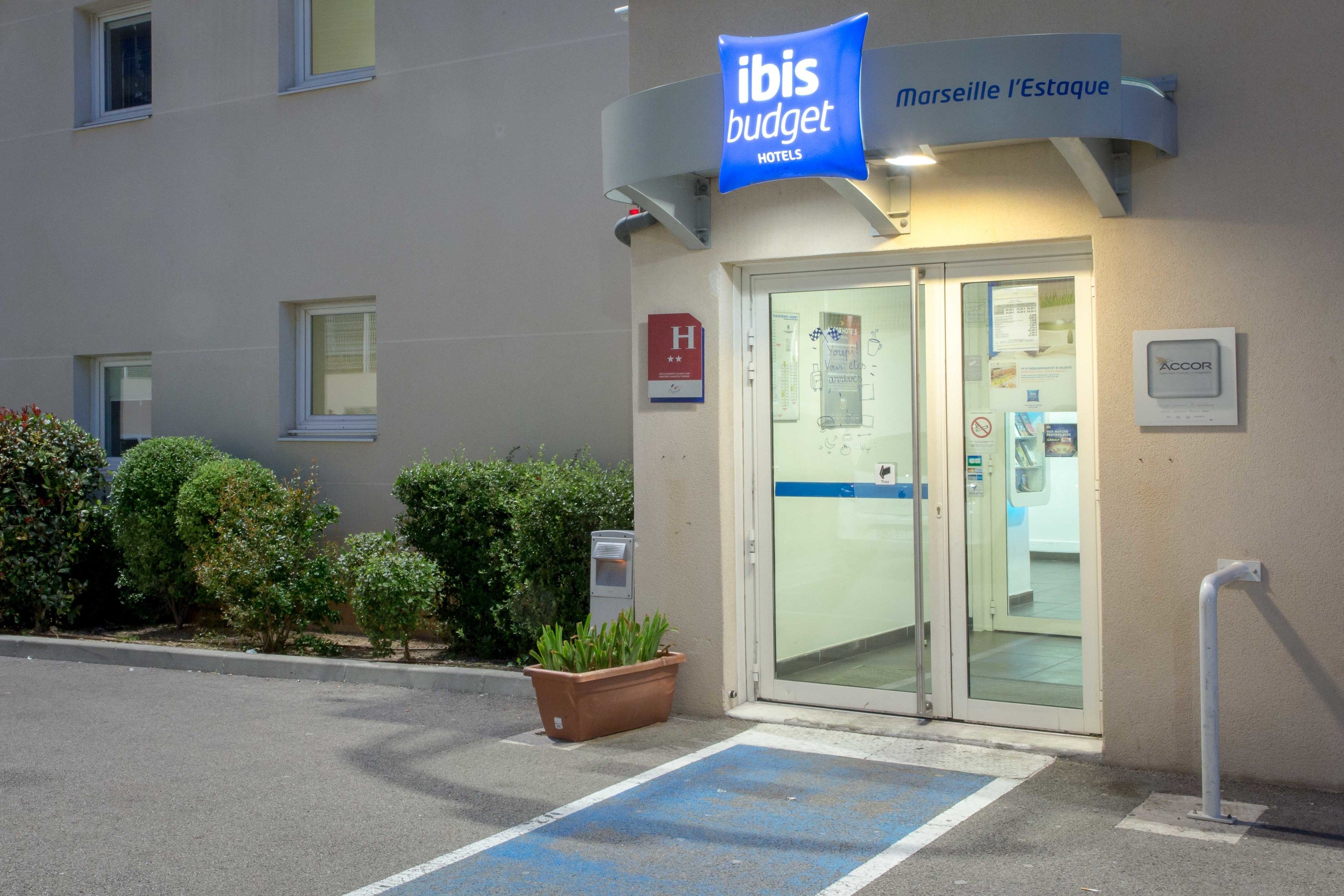Een exterieur van een budgethotel met een bord waarop staat: ibis budget Marseille l'Estaque HOTELS.